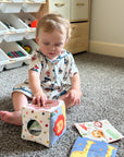 Baby playing with the LETSMAKE sensory tissue box toy and colorful fabric tissues.